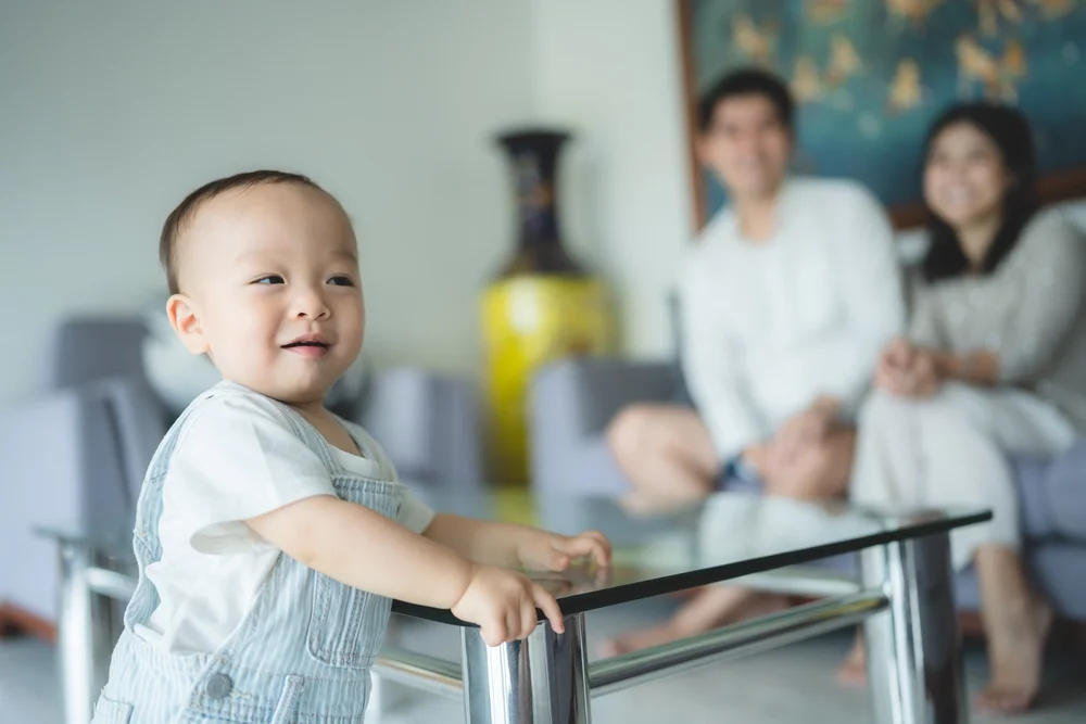 Toddler leaning on a glass table top